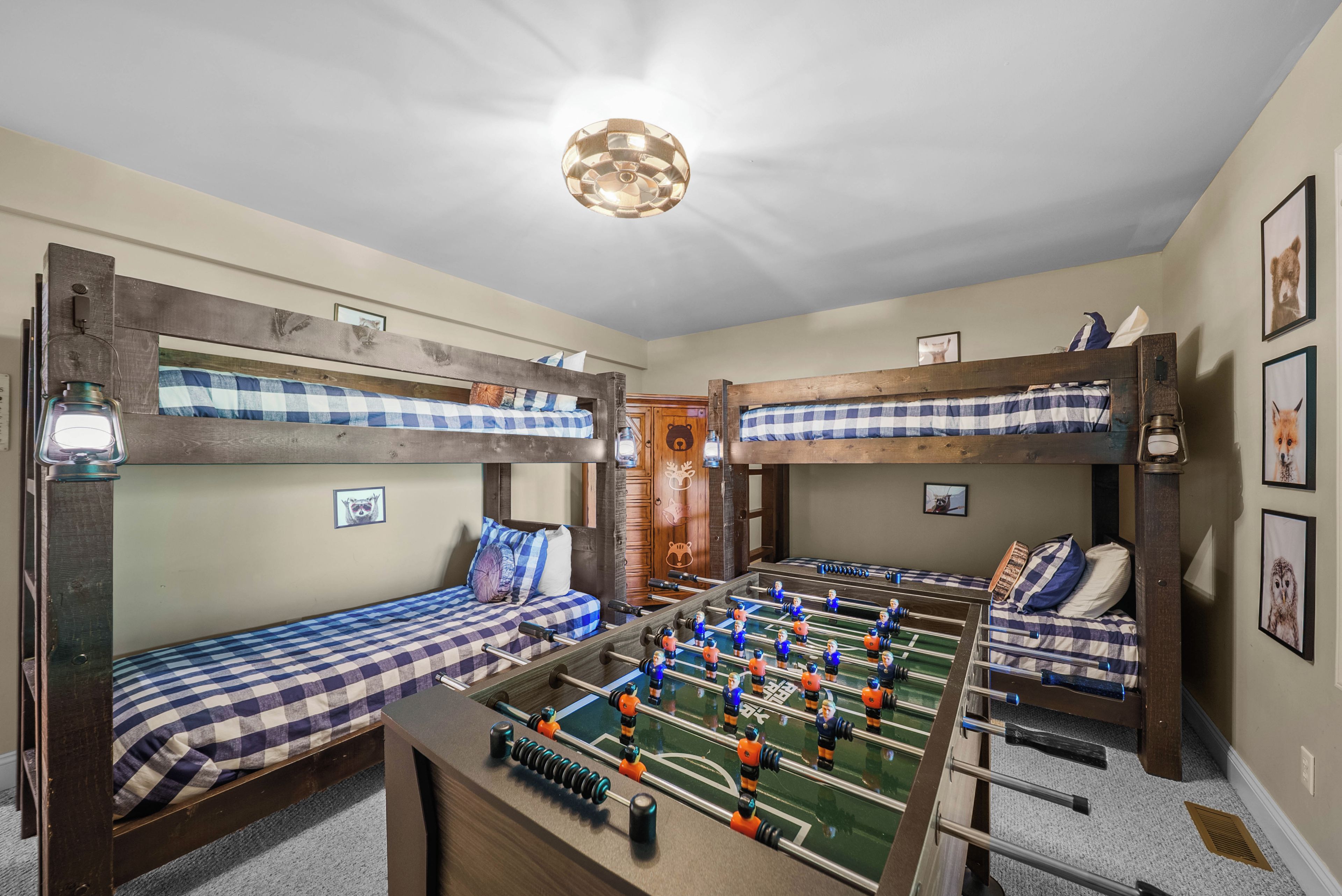 Una habitació amb llits superposats, una taula de futbolí i una llum al sostre.