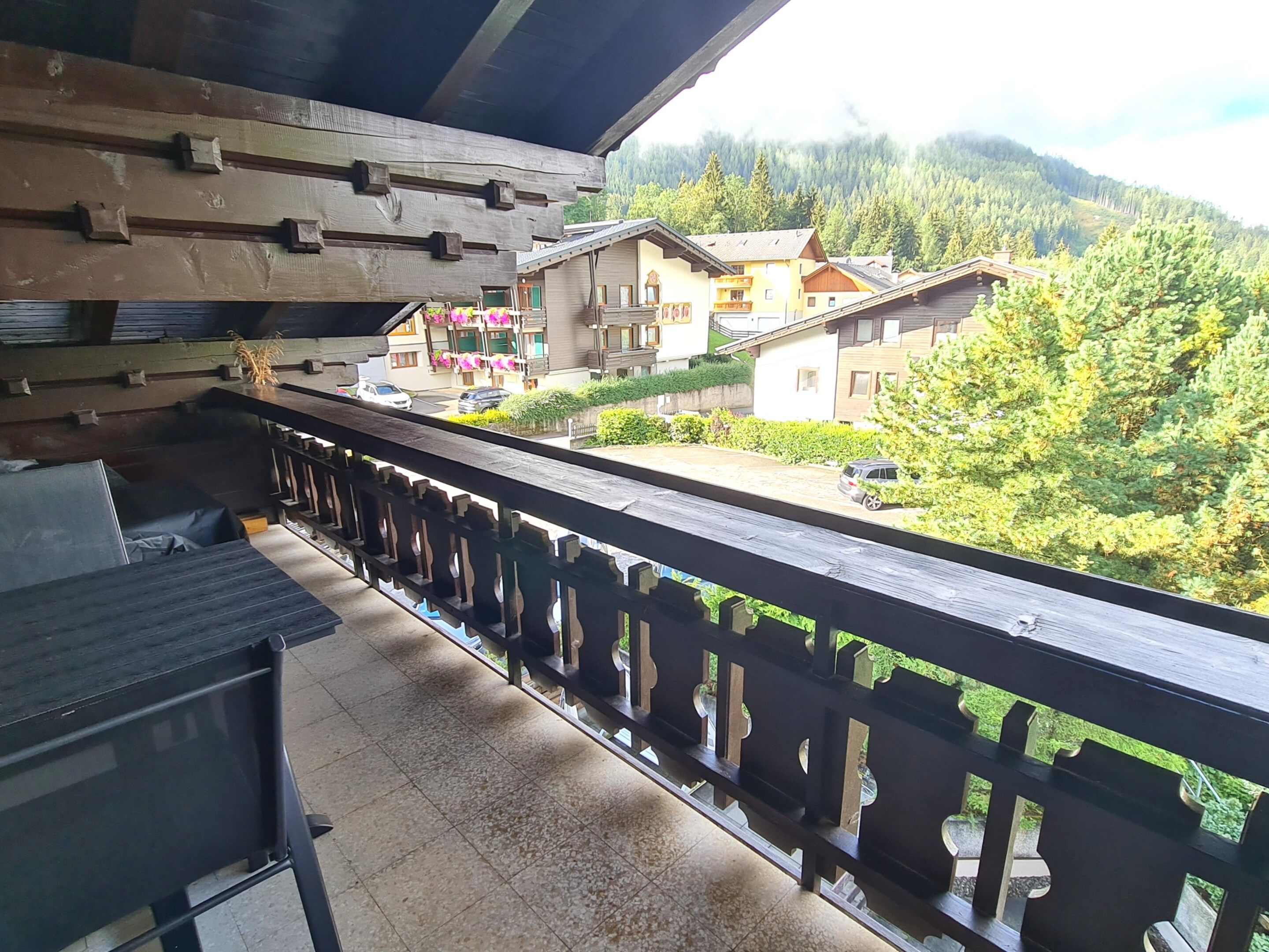 A balcony with a view of a residential area, including houses and greenery.