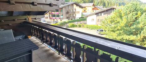 A balcony with a view of a residential area, including houses and greenery.