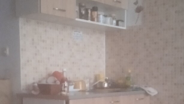 A kitchen with wooden cabinets, a countertop, and a backsplash. - Small Apartments City Center Retreat (Sarajevo)