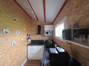 A compact kitchen with a microwave, sink, and a small window. - Chalet - Large terrace with a view of the golf course—near Albi (Rivières)