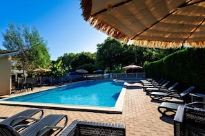 A swimming pool with lounge chairs and umbrellas.