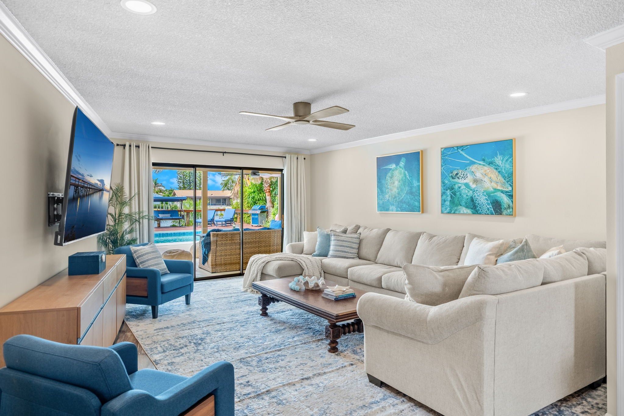 A living room with a sofa, chairs, a coffee table, and artwork on the walls.