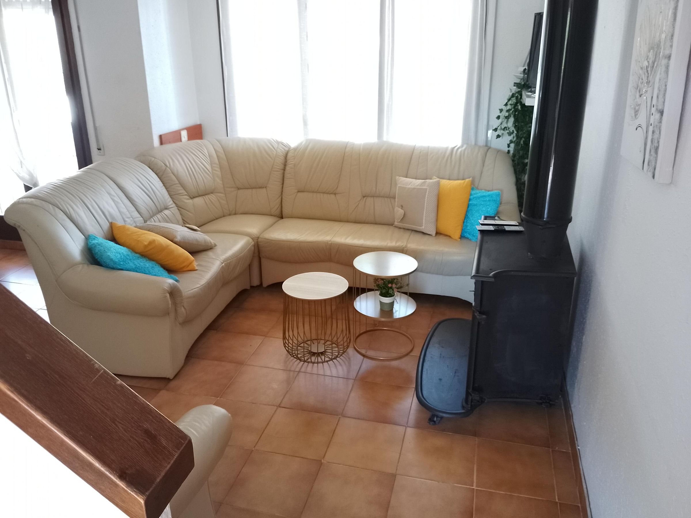 A living room with a beige sectional sofa, a small round coffee table, a TV on a stand, and a fireplace.