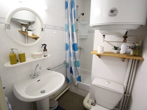 A compact bathroom with a sink, mirror, toilet, and shower. - Quiet apartment with parking, pets OK - 4 guests, mountain view (Bagnères-de-Luchon)