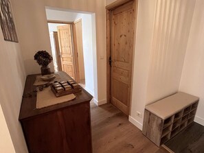 En gang med en trädør, en bænk og et bord med klodser, der staver 'HOME'.