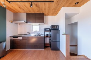 A modern kitchen with wooden cabinets, a built-in oven, and a refrigerator.