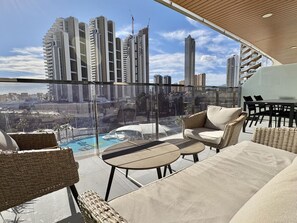 A balcony with outdoor furniture, a glass enclosure, and a view of high-rise buildings. - Apartment with panoramic view - 6 guests (Benidorm)