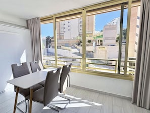 Ein Zimmer mit einem großen Fenster, einem Tisch und vier Stühlen.