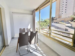 Ein Balkon mit Blick auf eine Stadtansicht, einer Tür und zwei Stühlen.