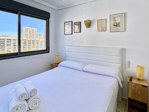 A hotel room with a bed, a window, and wall-mounted decor. - Modern apartment near the beach - 4 guests (Villajoyosa)