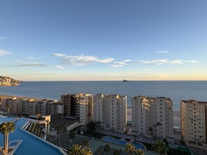 Ein Küstenwohngebiet mit Hochhäusern, einem Schwimmbad und Blick auf das Meer.
