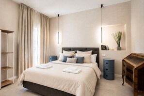 A modern bedroom with a bed, bedside tables, a wardrobe, and a mirror. - Vrbo Property (arezzo)
