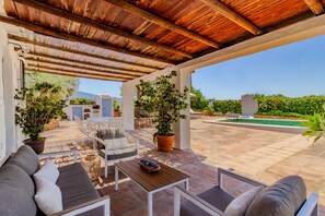 An outdoor patio with a wooden ceiling, a pool, and potted plants. - Zambra in Frigiliana (Frigiliana)