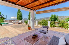 A covered outdoor patio with a pool, seating area, and a view of the hills. - Zambra in Frigiliana (Frigiliana)