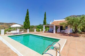 A swimming pool with a tiled deck, surrounded by outdoor furniture and a pergola. - Zambra in Frigiliana (Frigiliana)