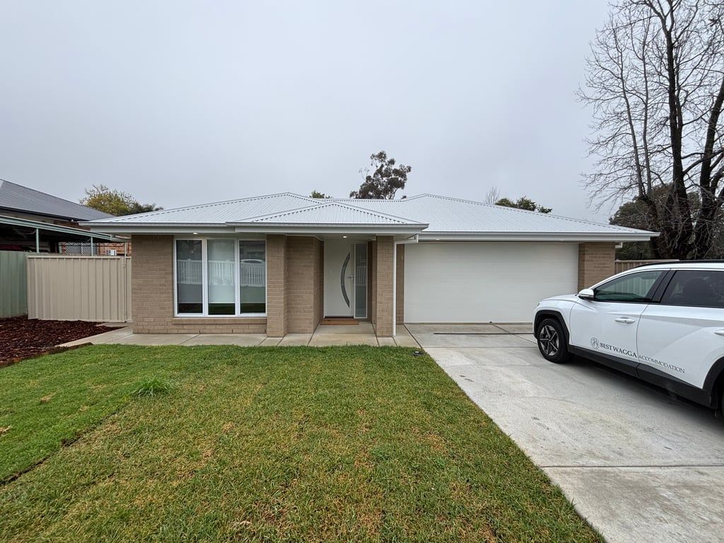 A residential house with a garage, a driveway, and a lawn.