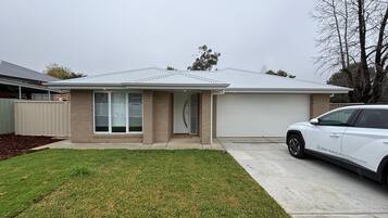 A residential house with a garage, a driveway, and a lawn.