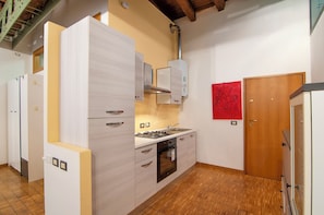 A compact kitchen with white cabinetry, a built-in oven, and a stove. - Kedimore - RomeoHouse (Verona)