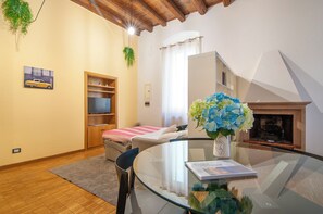 A cozy room with a bed, a glass table, a fireplace, and a bookshelf. - Kedimore - RomeoHouse (Verona)
