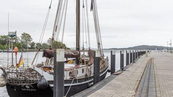 En förtöjd segelbåt med namnet ”MUGLITZ”, utrustad med ett nät i fören, rep och en flagga.