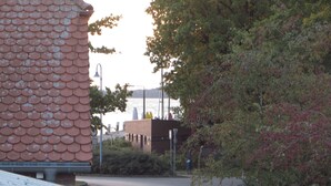 Un edifici amb un teulat de rajoles característic, un camí pavimentat i una massa d'aigua al fons.