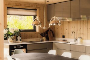 Una cocina moderna con armarios de madera, una isla central y una mesa de comedor.