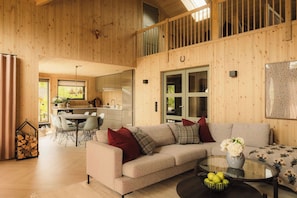 A spacious living area with a sofa, a dining table, and a kitchen in the background.