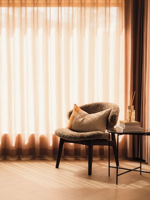 Una habitación con una silla, una mesita y un libro.