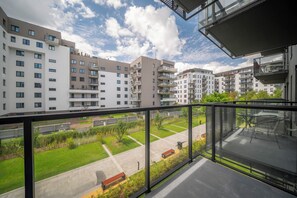 Un moderno complejo de apartamentos con varios balcones, cielo despejado y un césped bien cuidado.