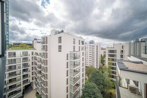 Een meerlaags woongebouw met balkons, een plat dak en een heldere lucht.