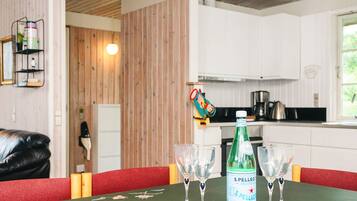 Een eettafel met een fles S. Pellegrino bruisend water en vier glazen.
