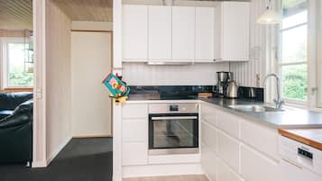 Een moderne keuken met witte kasten, een inbouwoven en een Siemens vaatwasser.