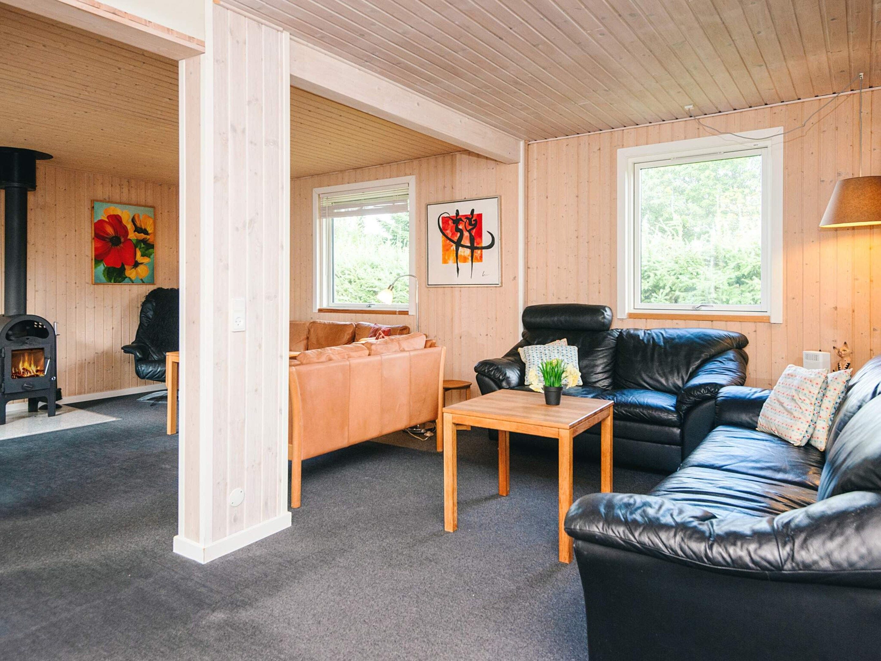 Ein gemütliches Wohnzimmer mit Kamin, Ledersofas und Holzboden.