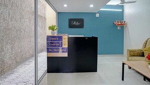 A reception desk with a sign indicating check-in and check-out times, a no-smoking sign, and a logo for 'Collection'. - Classic Bhumi Stay inn (Bhiwandi)