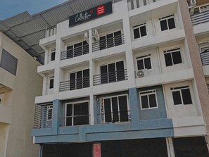 A multi-story hotel building with balconies, air conditioning units, and a sign indicating it is the Hotel Bhumi World. - Classic Bhumi Stay inn (Bhiwandi)