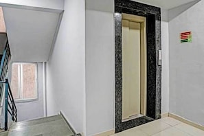 A hallway with a door leading to a room, a window, and a sign on the wall.