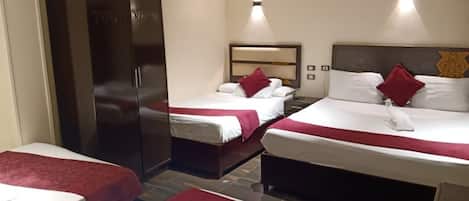 A hotel room with two beds, a wardrobe, and a nightstand.