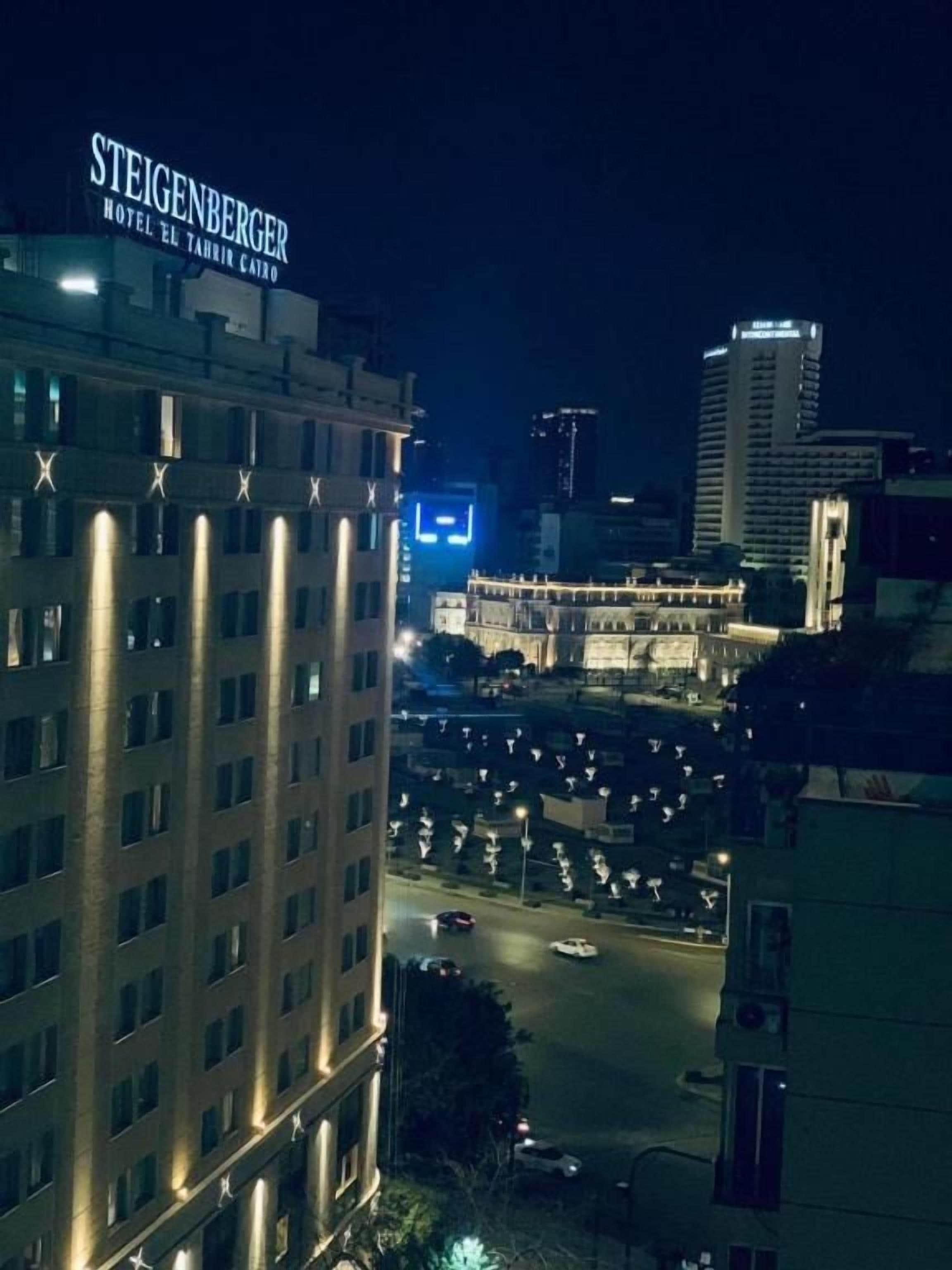 Un hotel anomenat Steigenberger amb vista a un paisatge urbà de nit.