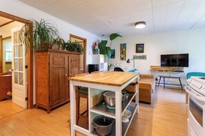 A compact kitchen with a wooden table, cabinets, and a microwave. - KazaLutins | Plage privée | Petit coin de paradis (Saint-Élie-de-Caxton)