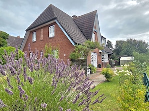 A two-story house with a brick facade and a sloped roof. - Tewelken Apartment - Tewelken Apartment in Wrixum - quiet location, modern (Wrixum)