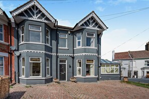 A two-story house with a bay window, a front door, and a small porch area. - Host & Stay | House On The Hill (Hastings)