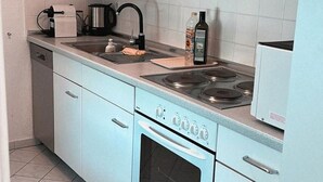 Eine Küche mit Herd, Backofen, Spüle und Kaffeemaschine.