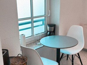 A small room with a round table and two chairs, a window with a view, and a radiator. - Sellin - Selene Vacation Rental - Lakeview Apartment (Sellin)