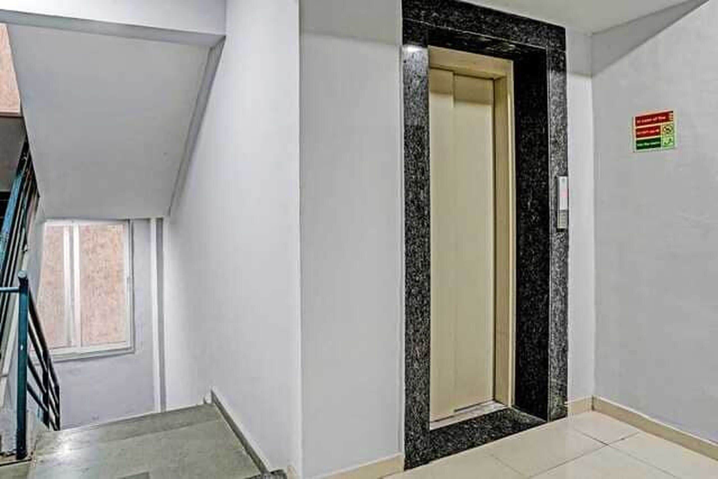 A hallway with a door leading to a room, a window, and a sign on the wall.
