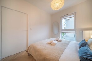 A bedroom with a bed, a window, a door, and a ceiling light fixture. - Kierbedzia Suite (Warszawa)