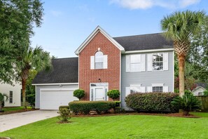 A two-story house with a brick facade and a grey siding exterior. - The Chantrell Pool Hot Tub Pets (North Charleston)