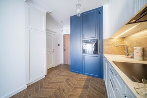 A modern kitchen with a herringbone floor, a blue cabinet, and a stainless steel sink. - Kierbedzia Elegant Classic Blinds, Free Parking, Mokotow, Warsaw (Warszawa)