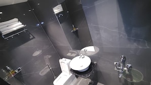 A modern bathroom with a toilet, bidet, and sink, all with chrome fixtures. - Swaraj Homestay (Varanasi)