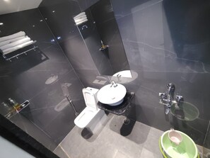 A modern bathroom with a toilet, bidet, and sink, all with chrome fixtures. - Swaraj Homestay (Varanasi)